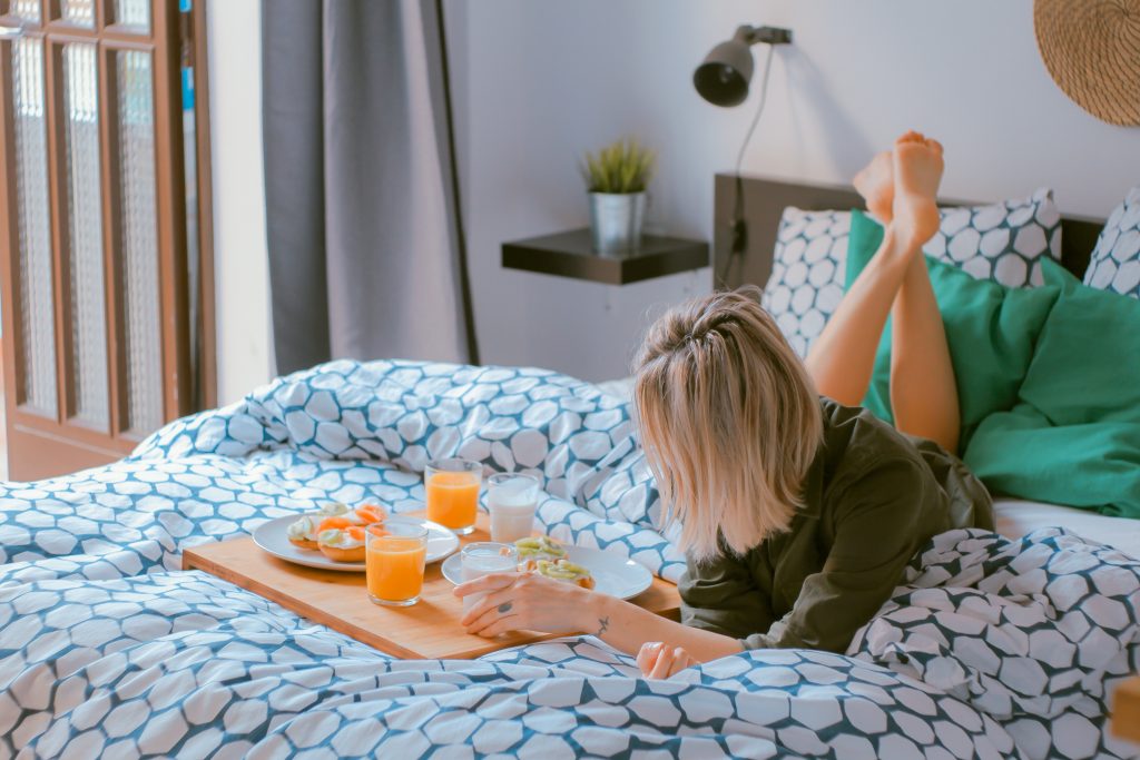 femme blonde qui prend son petit déjeuner au lit